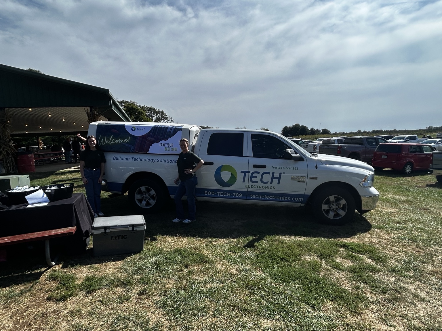 The Tech Electronics event truck beside the NILO Farms gathering and packed parking area